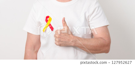 World hepatitis day awareness month, 28 July. elderly woman with Red and Yellow ribbon. Liver cancer, Jaundice, Cirrhosis, Failure, Enlarged, Hepatic Encephalopathy and Health concept 127952627