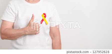 World hepatitis day awareness month, 28 July. elderly woman with Red and Yellow ribbon. Liver cancer, Jaundice, Cirrhosis, Failure, Enlarged, Hepatic Encephalopathy and Health concept 127952628