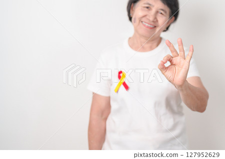 World hepatitis day awareness month, 28 July. elderly woman with Red and Yellow ribbon. Liver cancer, Jaundice, Cirrhosis, Failure, Enlarged, Hepatic Encephalopathy and Health concept 127952629