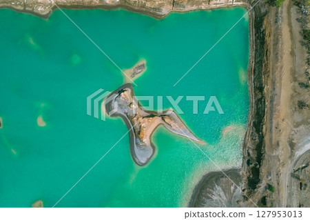 The effects of pollution on a natural habitat, featuring damaged terrain and pools of toxic water surrounded by lush hills. The effects of pollution on a natural habitat, featuring damaged terrain and pools of toxic water surrounded by lush hills. 127953013