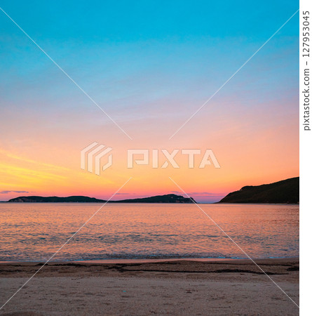 Vibrant sunset over tranquil beach captures natural beauty and serene atmosphere Vibrant sunset over tranquil beach captures natural beauty and serene atmosphere 127953045