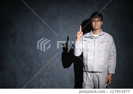 A man in work clothes pointing 127953977