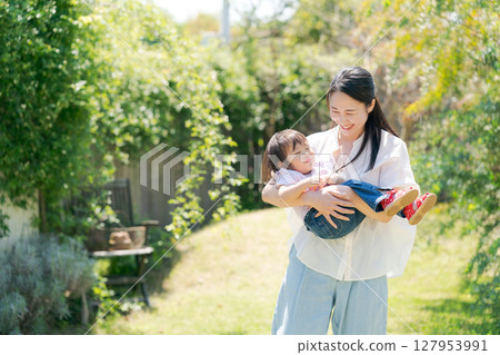 Parents and children playing in a garden with fresh greenery 127953991