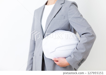 A middle-aged woman in a suit holding a helmet A middle-aged woman in a suit holding a helmet 127955151