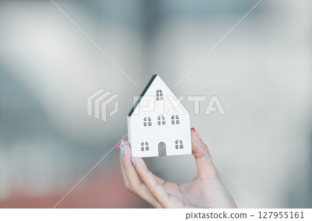 Woman hand hold key buy home model business concept involves sell financial management investment bank loan ownership income economy finance investments purchasing apartment blur background estate 127955161
