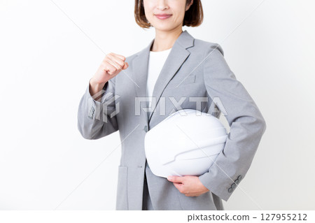 A middle-aged woman in a suit posing with a helmet 127955212