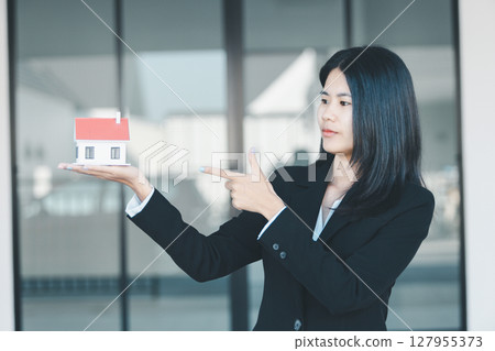 Woman hand hold key buy home model business concept involves sell financial management investment bank loan ownership income economy finance investments purchasing apartment blur background estate 127955373