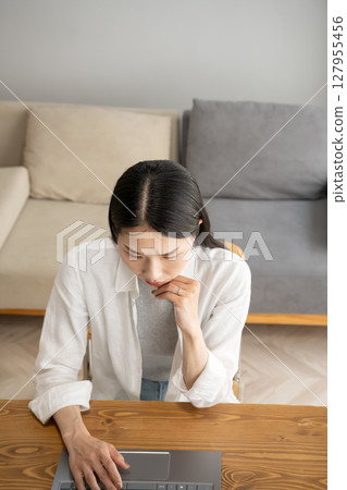 A woman troubled by looking at the screen of a personal computer A woman troubled by looking at the screen of a personal computer 127955456