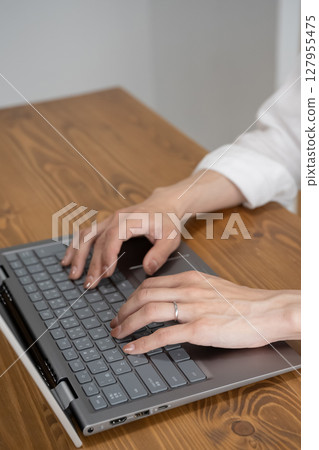 Hands of a woman working on a laptop Hands of a woman working on a laptop 127955475