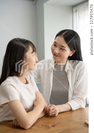 Girl getting her mother's makeup done Girl getting her mother's makeup done 127955478