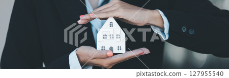 Woman hand hold key buy home model business concept involves sell financial management investment bank loan ownership income economy finance investments purchasing apartment blur background estate 127955540