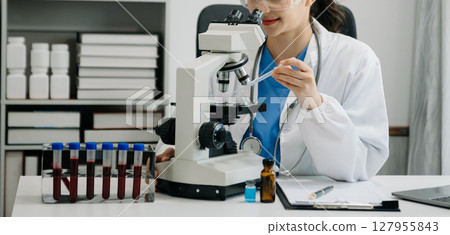 female scientist working with micro pipettes analyzing biochemical samples, advanced science chemical laboratory for medicine. female scientist working with micro pipettes analyzing biochemical samples, advanced science chemical laboratory for medicine. 127955843