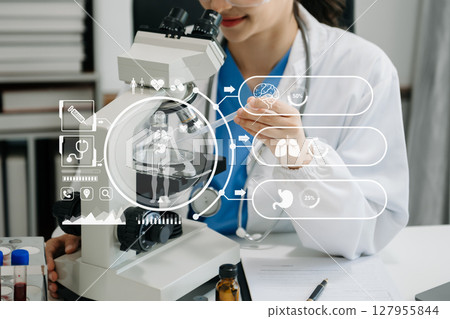 DNA molecule testing concepts. The doctor in a mask examines DNA molecules on the chemical laboratory with virtual icon DNA molecule testing concepts. The doctor in a mask examines DNA molecules on the chemical laboratory with virtual icon 127955844
