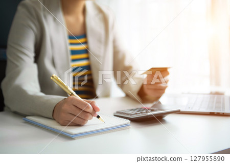 Businesswoman using calculator with credit card for shopping internet online and financial business strategy 127955890