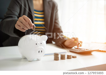 Business woman hand putting money coin into piggy bank with step of growing stack coins for saving money with virtual icon Business woman hand putting money coin into piggy bank with step of growing stack coins for saving money with virtual icon 127955893