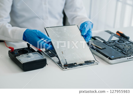 Electronics technician, electronic engineering electronic repair,electronics measuring and testing, repair and maintenance concepts.uses a voltage meter to check and upgrade in shop Electronics technician, electronic engineering electronic repair,electronics measuring and testing, repair and maintenance concepts.uses a voltage meter to check and upgrade in shop 127955983