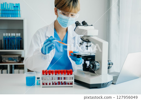 Modern medical research laboratory. female scientist working with micro pipettes analyzing biochemical samples, advanced science chemical laboratory Modern medical research laboratory. female scientist working with micro pipettes analyzing biochemical samples, advanced science chemical laboratory 127956049