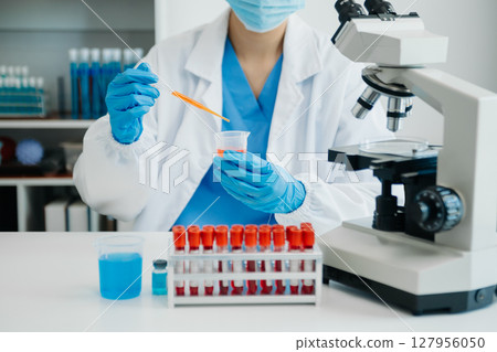 Modern medical research laboratory. female scientist working with micro pipettes analyzing biochemical samples, advanced science chemical laboratory Modern medical research laboratory. female scientist working with micro pipettes analyzing biochemical samples, advanced science chemical laboratory 127956050