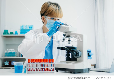 Modern medical research laboratory. female scientist working with micro pipettes analyzing biochemical samples, advanced science chemical laboratory 127956052