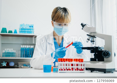 Modern medical research laboratory. female scientist working with micro pipettes analyzing biochemical samples, advanced science chemical laboratory 127956069