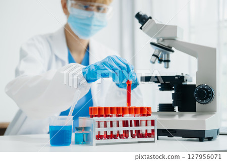 Modern medical research laboratory. female scientist working with micro pipettes analyzing biochemical samples, advanced science chemical laboratory Modern medical research laboratory. female scientist working with micro pipettes analyzing biochemical samples, advanced science chemical laboratory 127956071