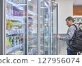 Customer Carefully Chooses Refreshing Products At Store 127956074