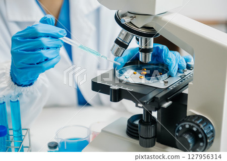 Modern medical research laboratory. female scientist working with micro pipettes analyzing biochemical samples, advanced science chemical laboratory Modern medical research laboratory. female scientist working with micro pipettes analyzing biochemical samples, advanced science chemical laboratory 127956314