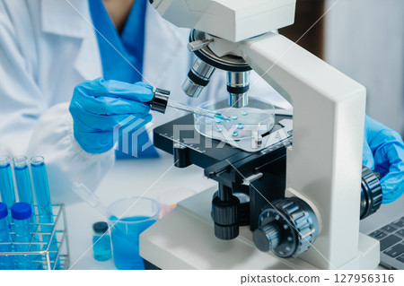 Modern medical research laboratory. female scientist working with micro pipettes analyzing biochemical samples, advanced science chemical laboratory 127956316