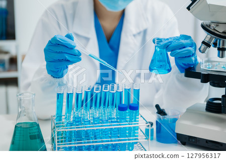 Modern medical research laboratory. female scientist working with micro pipettes analyzing biochemical samples, advanced science chemical laboratory 127956317