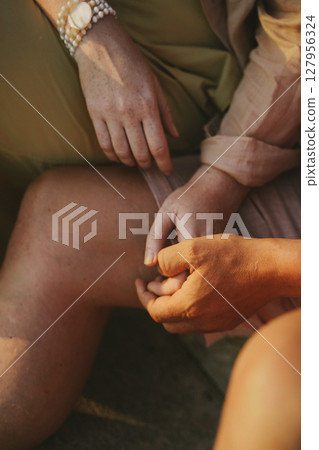 Tender Moment of Hand Holding Between Two People 127956324