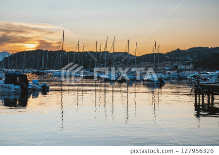 Boats Docked in Harbor at Sunset with Calm Reflections 127956326