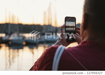 Capturing Scenic Sunset with Smartphone at Harbor Capturing Scenic Sunset with Smartphone at Harbor 127956327