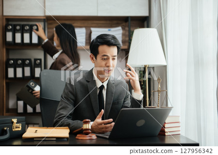 Business Asian people and lawyers discussing contract papers sitting at the table. Concepts of law, advice, legal services. 127956342