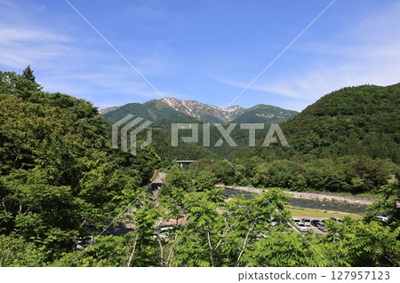 Shirakawa-go's greenery and snow-capped ridgelines - a spectacular view of early summer from the parking lot 127957123