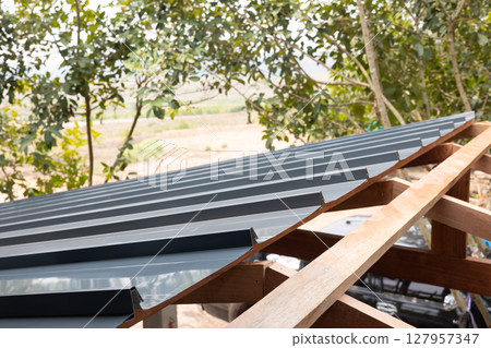 Roof under construction with metal sheet and wood structure. Roof under construction with metal sheet and wood structure. 127957347