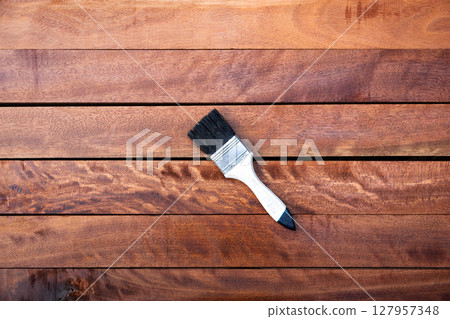 Paint brush and wood material in construction work. Paint brush and wood material in construction work. 127957348