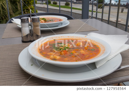 Fish soup on a table in a restaurant Fish soup on a table in a restaurant 127958564