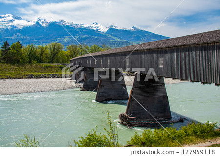 Covered wooden old bridge (Alte Rheinbrucke) the across the river Rhine between Vaduz, Liechtenstein and Sevelen, Switzerland Covered wooden old bridge (Alte Rheinbrucke) the across the river Rhine between Vaduz, Liechtenstein and Sevelen, Switzerland 127959118