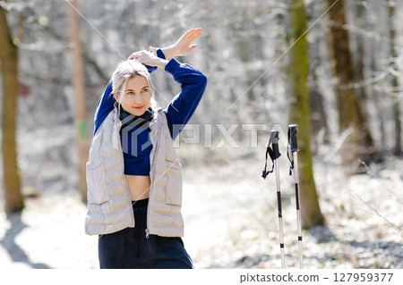 Young woman stretching before nordic walking in forest Young woman stretching before nordic walking in forest 127959377