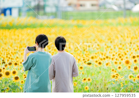 <安曇野> 一對情侶在新村的向日葵田裡玩耍 127959535