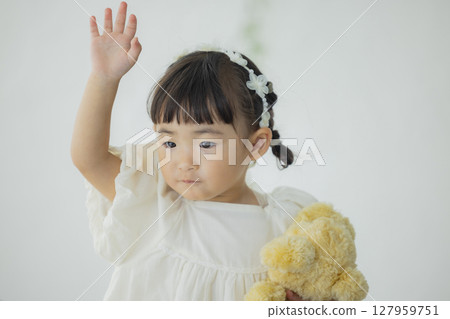 Girl holding a stuffed animal 127959751