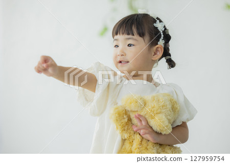 Girl holding a stuffed animal Girl holding a stuffed animal 127959754