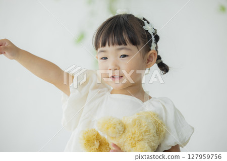 Girl holding a stuffed animal 127959756