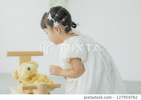 Girl holding a stuffed animal 127959762