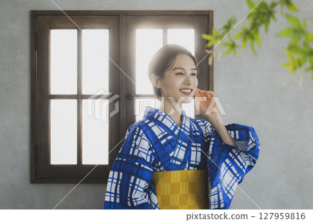 A woman in a yukata by the window 127959816