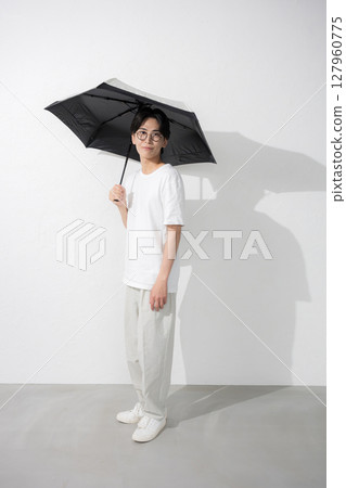 Full body of a man holding a parasol 127960775
