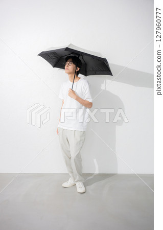 Full body of a man holding a parasol Full body of a man holding a parasol 127960777