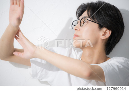 A man wearing glasses applying sunscreen A man wearing glasses applying sunscreen 127960914