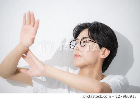 A man wearing glasses applying sunscreen A man wearing glasses applying sunscreen 127960915