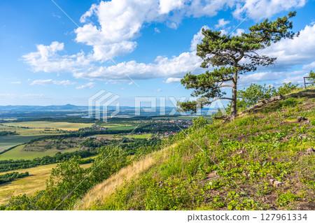 Visitors enjoy breathtaking views from Roudnice Lookout Point on Rip Mountain. Lush greenery and a clear sky create a perfect backdrop for relaxation and exploration. Visitors enjoy breathtaking views from Roudnice Lookout Point on Rip Mountain. Lush greenery and a clear sky create a perfect backdrop for relaxation and exploration. 127961334